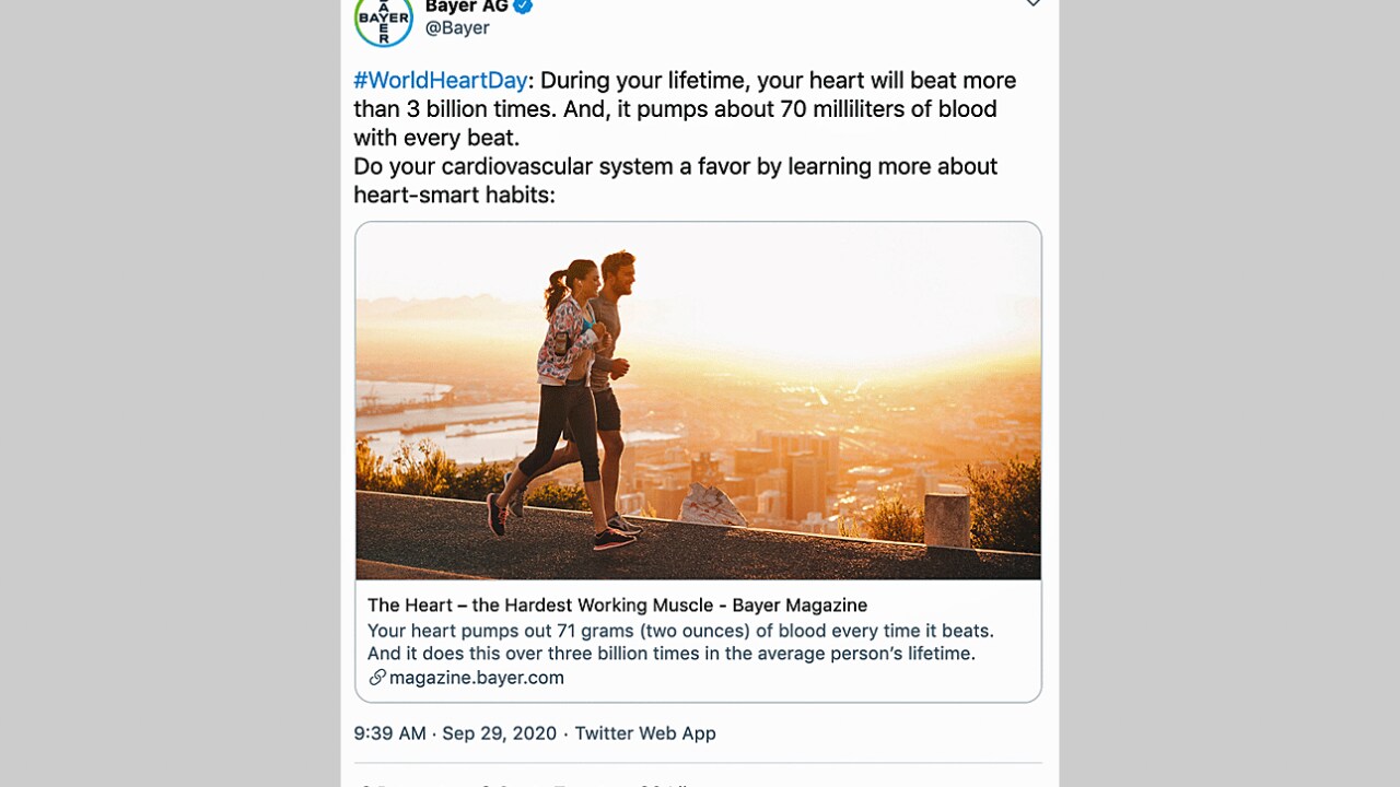 A man and woman jog together at sunrise on a scenic path overlooking water, as featured in a tweet about heart health from Bayer AG.