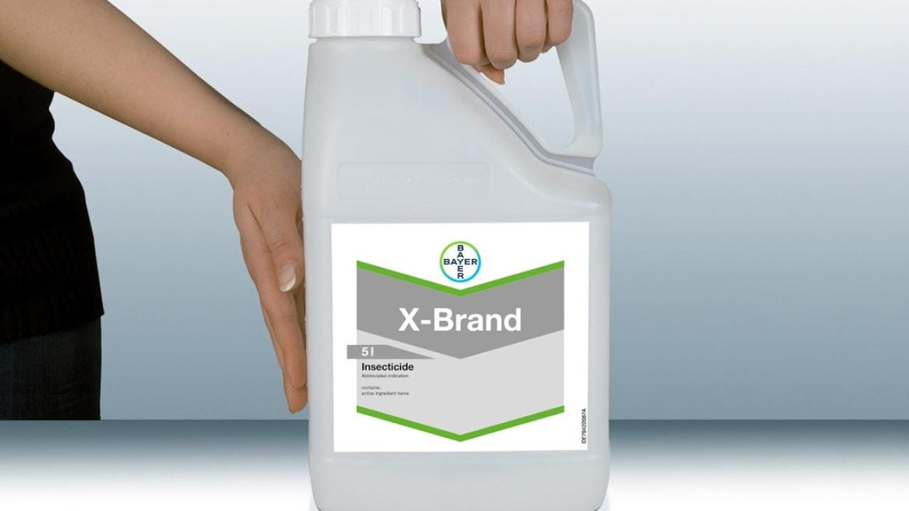 Person holding a 5-liter container of X-Brand insecticide with a label featuring green and gray accents.