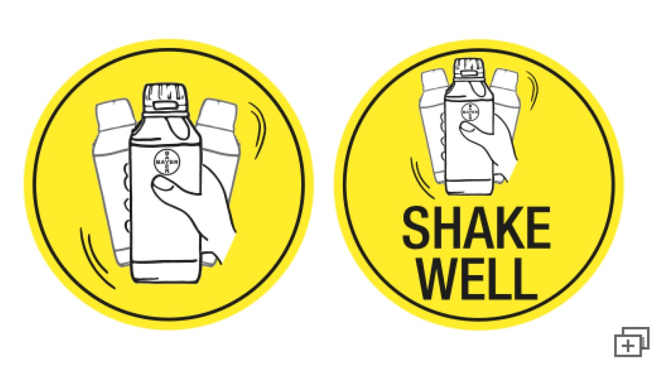 Two yellow circular signs showing a hand shaking a bottle. One sign has the text "SHAKE WELL.