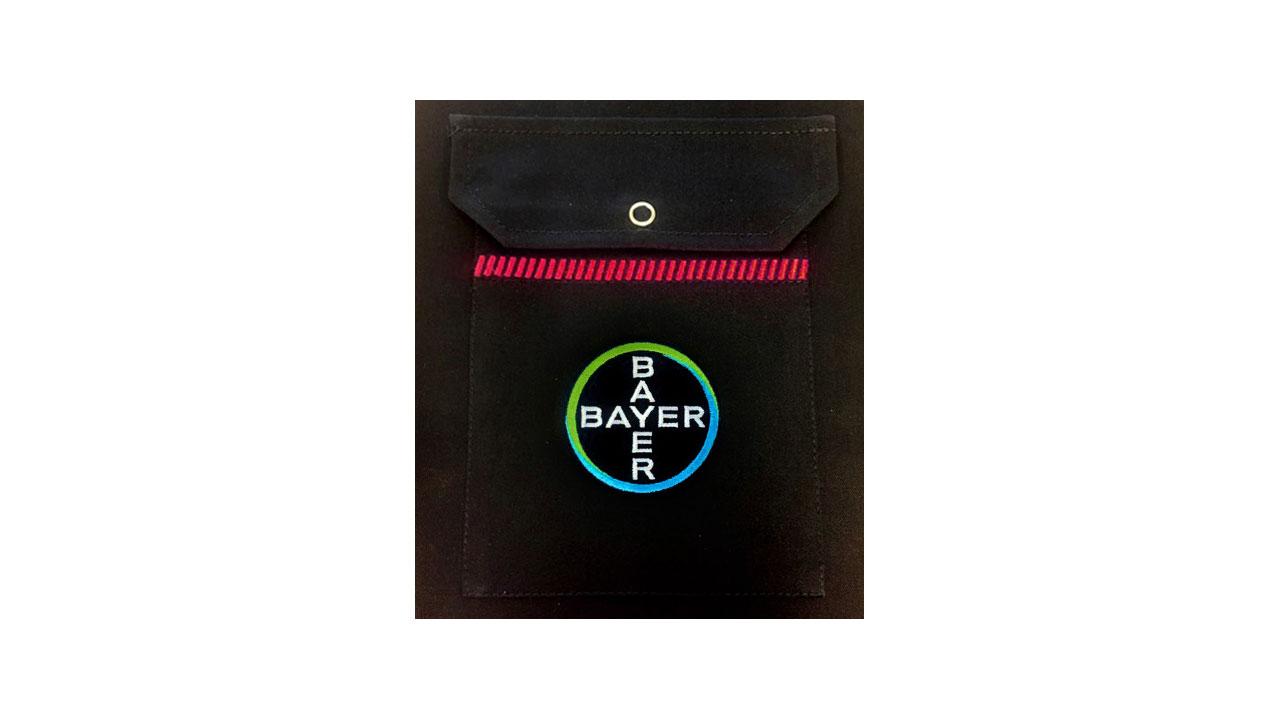 A black pouch with a circular patch displaying the word "BAYER" in blue text vertically and horizontally.