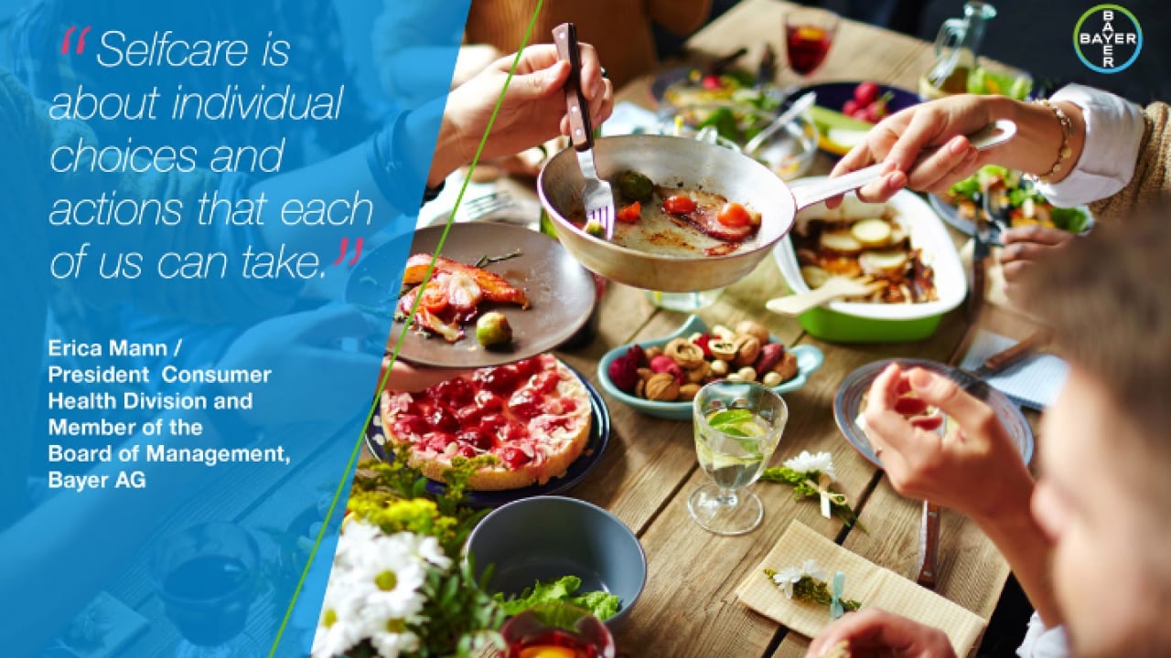 A group of people sharing a meal at a table with various dishes, including pizza and salad. A quote about self-care is visible in the upper left corner.