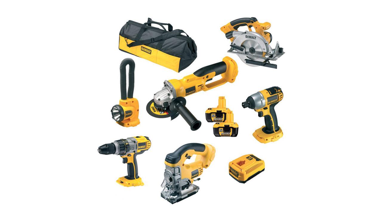 A set of yellow and black power tools, including a drill, circular saw, reciprocating saw, angle grinder, jigsaw, flashlight, batteries, and a carrying bag.