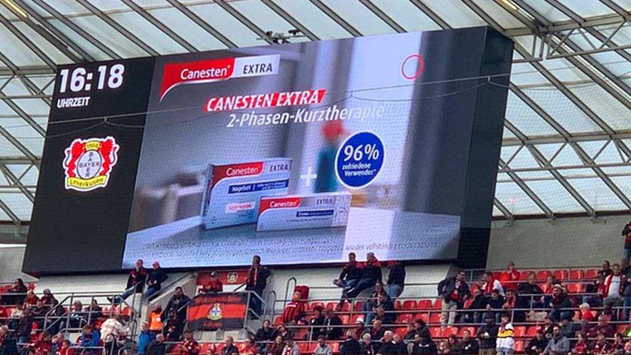 Soccer stadium scoreboard with advertising Canesten