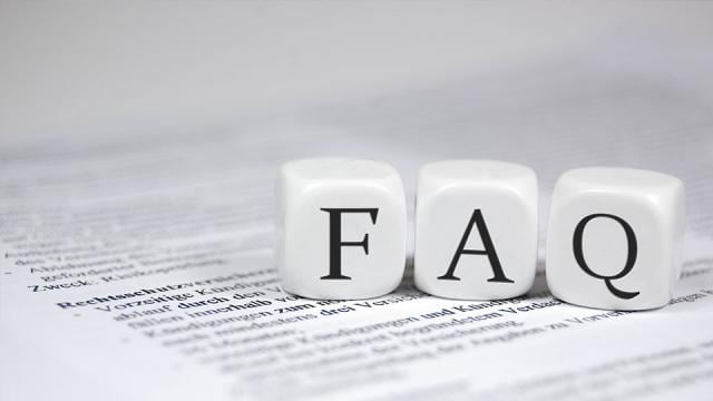 Three white dice with the letters F, A, and Q rest on a printed document background.