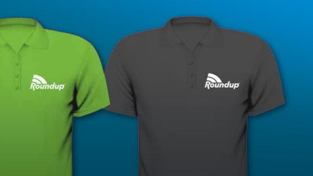 Two polo shirts side by side: one green, one gray, both with the "Roundup" logo on the left chest. Background is blue.