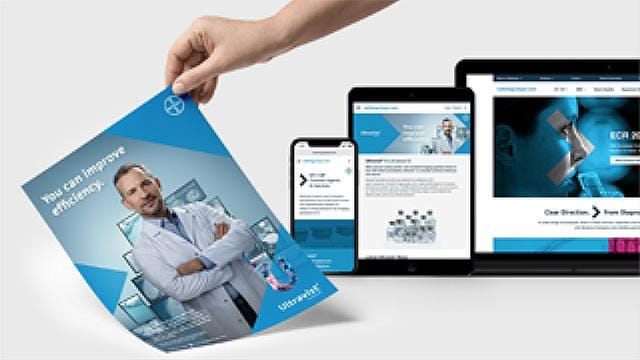 A hand holding a brochure with a doctor on the cover next to a smartphone, tablet, and laptop displaying similar themed content.