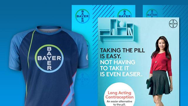 A Bayer-branded shirt and a promotional poster featuring a woman, with text about long-acting contraception as an alternative to the pill.