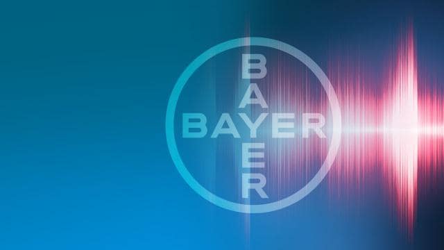 Bayer logo on a blue background with pink and white light waves extending from the right side.