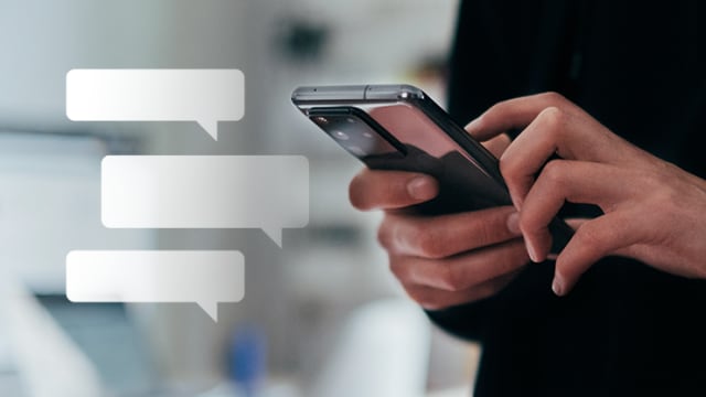 A person texting on a smartphone with chat bubbles in the foreground.