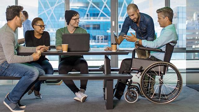 Group of people around a table, one person is in a wheelchair