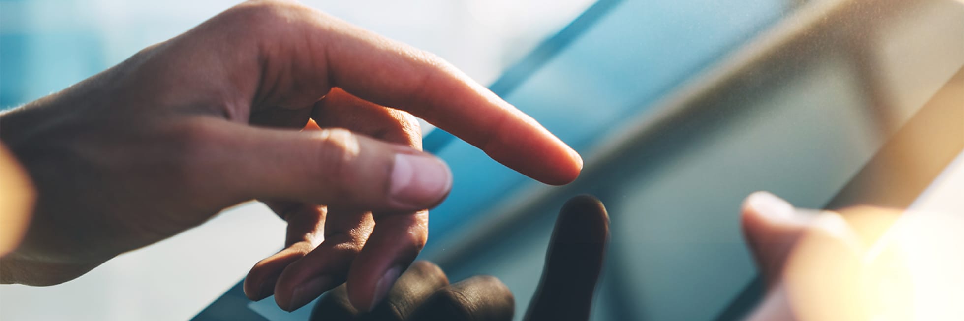 Fingers tapping and swiping on a touchscreen device in a close-up view.