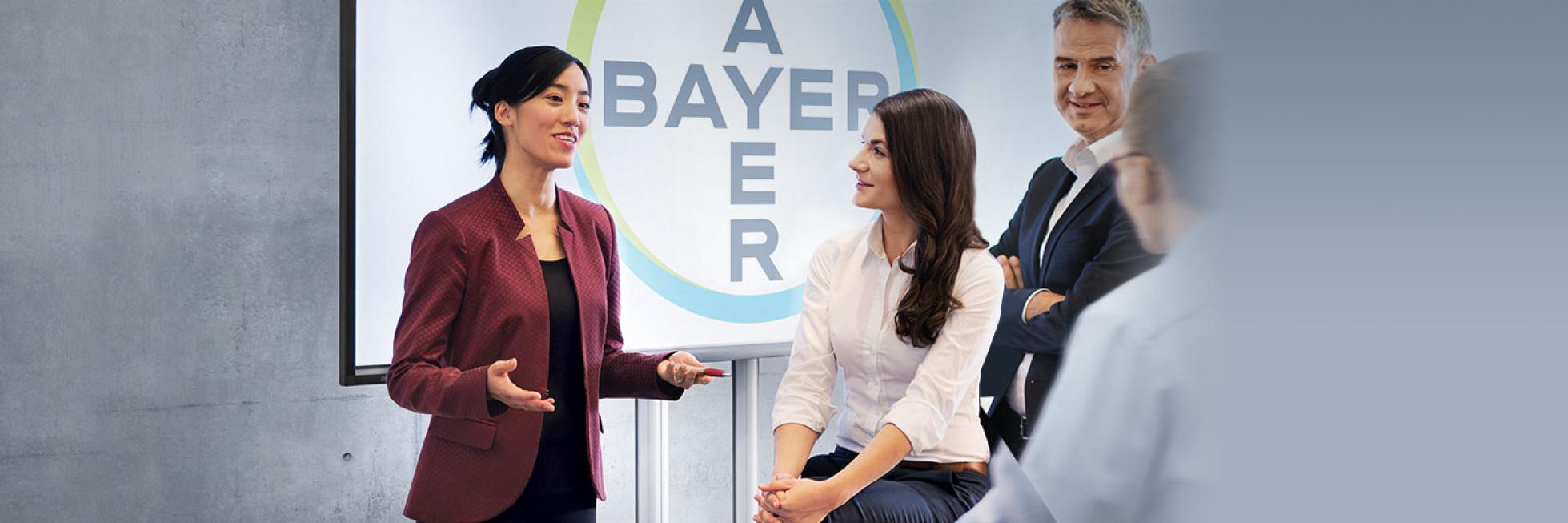 Group discussed in front of the screen with Bayer Cross