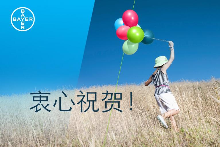 A person with balloons runs through a grassy field under a clear blue sky, with a large Bayer logo in the corner and Chinese text on the left.
