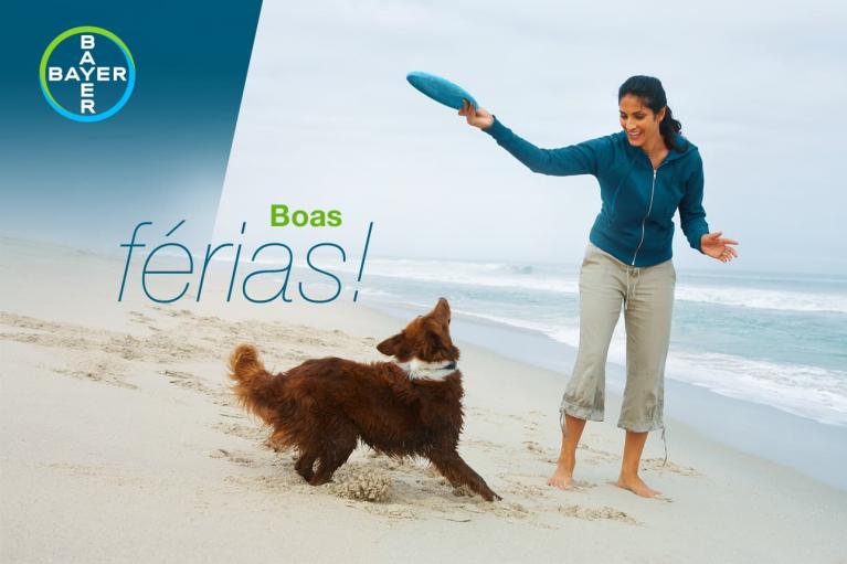 Woman playing fetch with a dog on a beach. Bayer logo and text "Boas férias!" are visible.