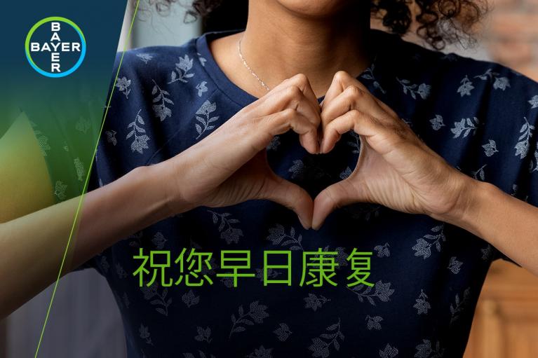 A person forms a heart shape with their hands, with Chinese text below. A Bayer logo is in the top left corner.