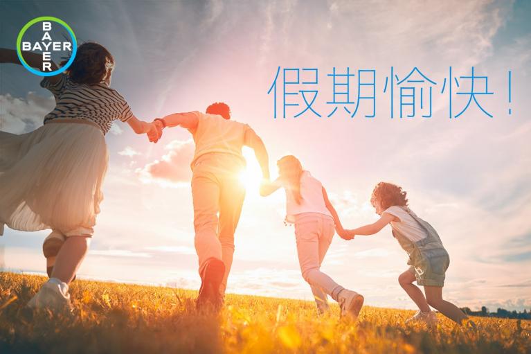 A family of four holds hands and runs through a sunny field. The Bayer logo is in the corner. Chinese text reads "假期愉快!" which translates to "Happy holidays!.