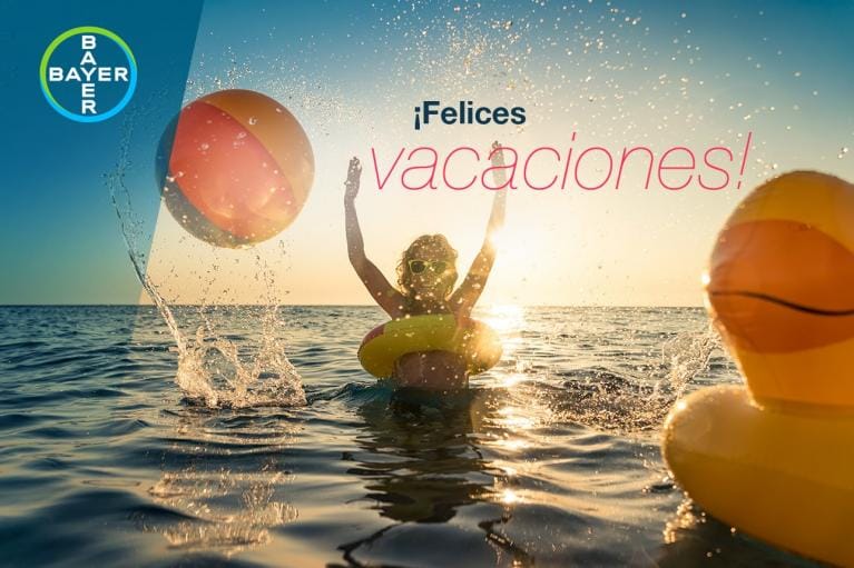 Person in water with floaties, splashing and enjoying the sunset. Text reads "¡Felices vacaciones!" Bayer logo in the corner.