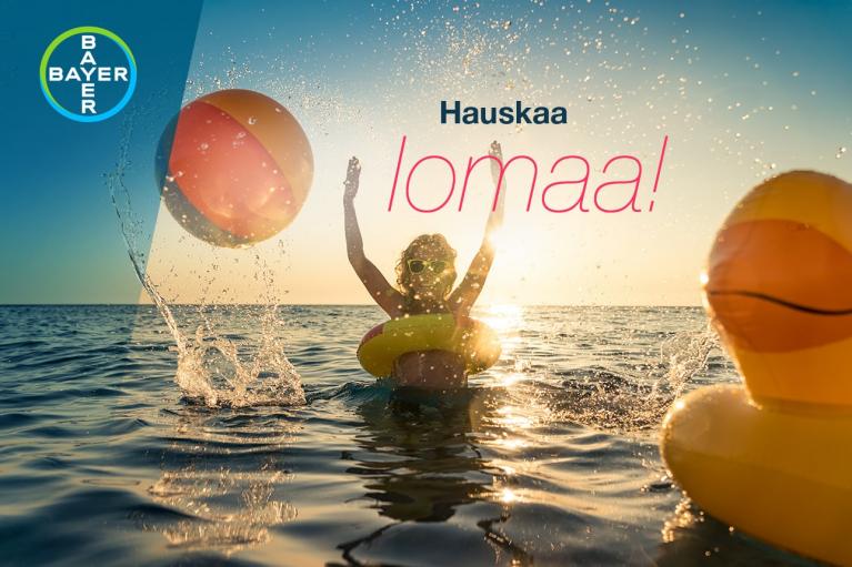 Person in the ocean at sunset, wearing a hat and inflatable ring, surrounded by a beach ball and inflatable duck. Text reads "Hauskaa lomaa!" with Bayer logo in the corner.