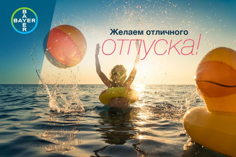 Person in water with inflatable rings and a beach ball, enjoying a sunset. Russian text reads "Желаем отличного отпуска!" ("Wishing you a great vacation!"). Bayer logo in the corner.