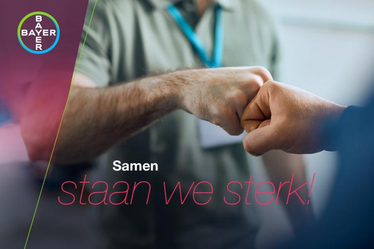 Two people fist-bump with a blurred background. The Bayer logo is in the top left corner. Dutch text reads, "Samen staan we sterk!.