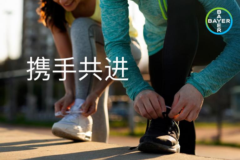 Two people in sportswear tying their sneakers outdoors, with a blurred background and Chinese text overlay.