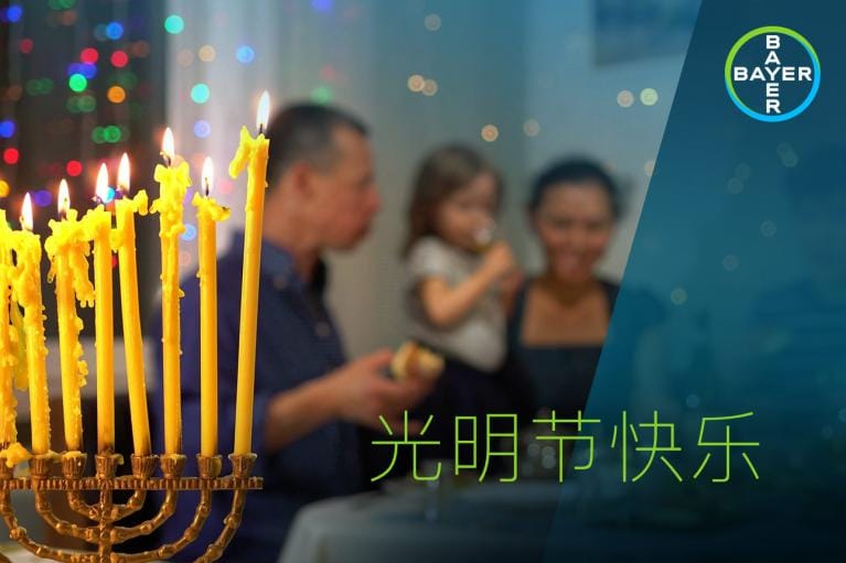 Candles are lit in the foreground. A family with a child is visible in the blurred background. Text reads "光明星快乐.