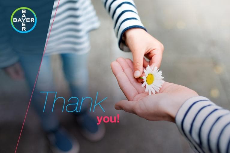 Two hands exchange a daisy flower. The words "Thank you!" are overlaid. A Bayer logo is in the top left corner.