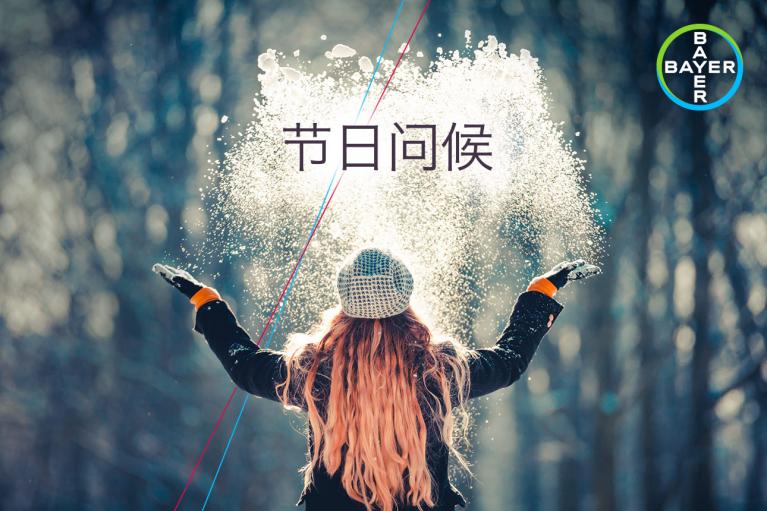 Person wearing winter clothing throws snow into the air in a forest. Text and logo are visible.