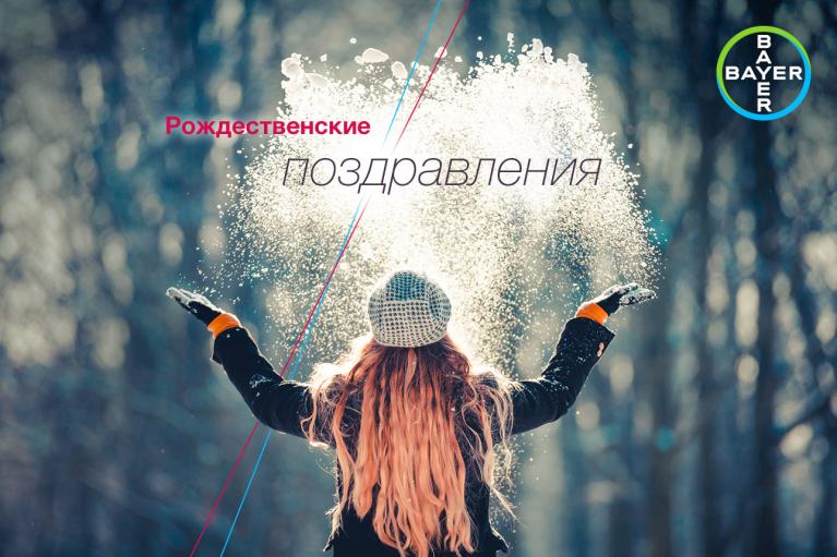 A person in winter clothing throws snow into the air in a forest. The text in Russian reads, "Christmas Greetings." The Bayer logo is visible in the top right corner.