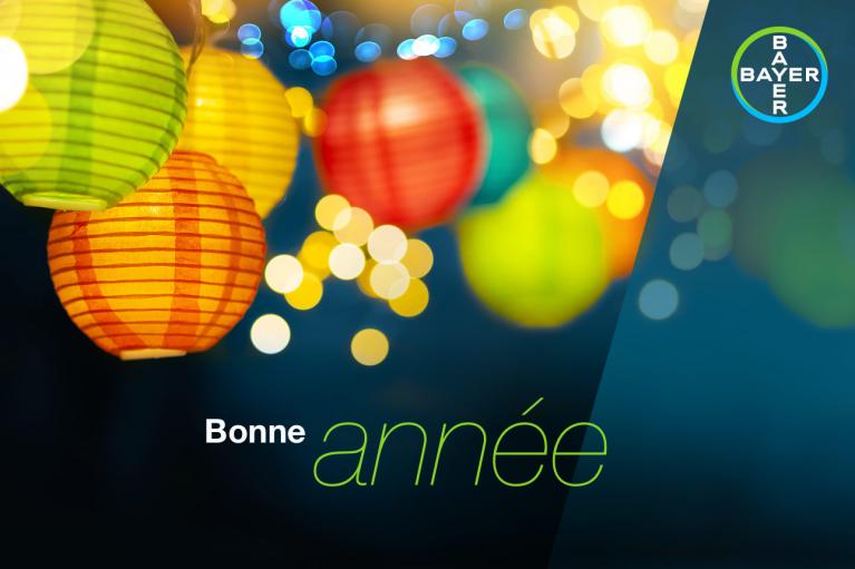 Bright paper lanterns with bokeh lights on a dark background. Text reads "Bonne année" with a Bayer logo in the corner.