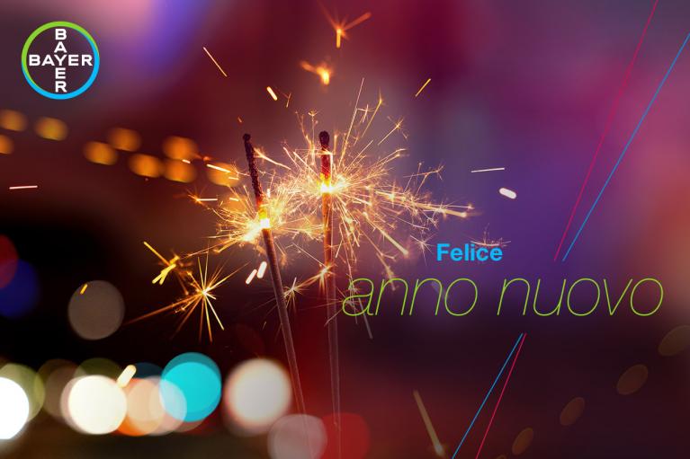 Sparklers with colorful lights in the background. Text reads "Felice anno nuovo" alongside Bayer logo in top left corner.
