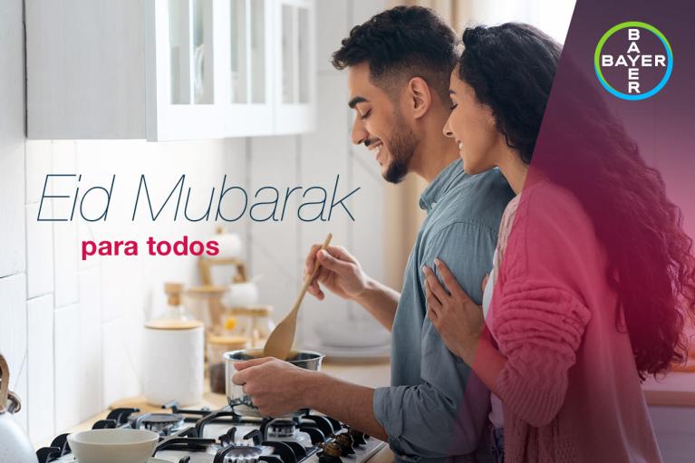 A couple cooking together in a kitchen, with the text "Eid Mubarak para todos" and a Bayer logo visible in the image.