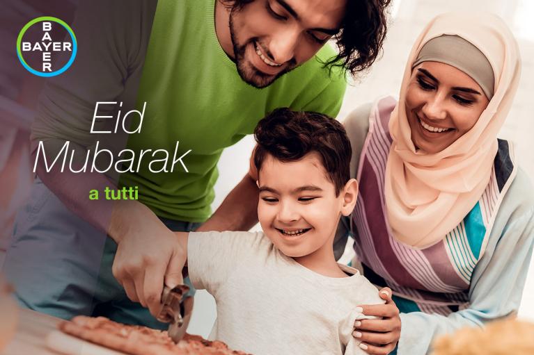 A happy family prepares food together, with the text "Eid Mubarak a tutti" and a Bayer logo in the corner.