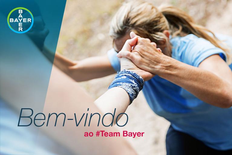 Two people holding hands, one assisting the other in climbing up, with the Bayer logo and text "Bem-vindo ao #Team Bayer" on the left.