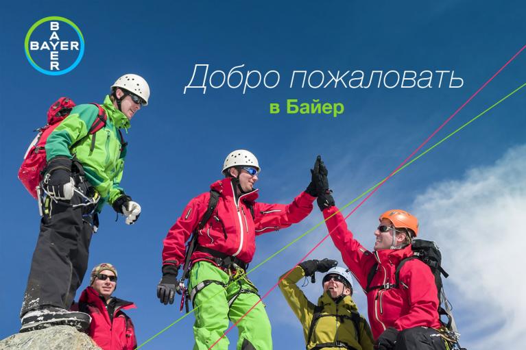 Four climbers in winter gear celebrate on a mountain with high fives. The Bayer logo and Russian text are present.