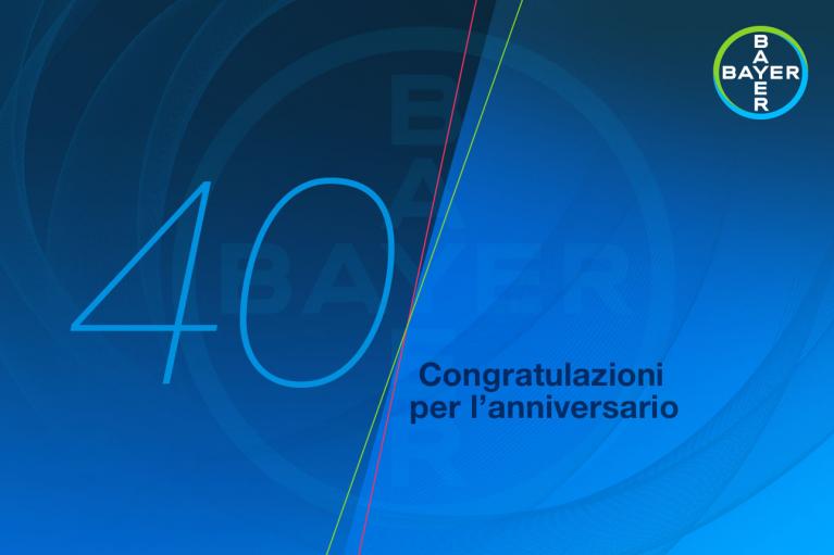 Blue graphic background with the number 40 and Bayer logo. Italian text reads, "Congratulazioni per l'anniversario" meaning "Congratulations for the anniversary.