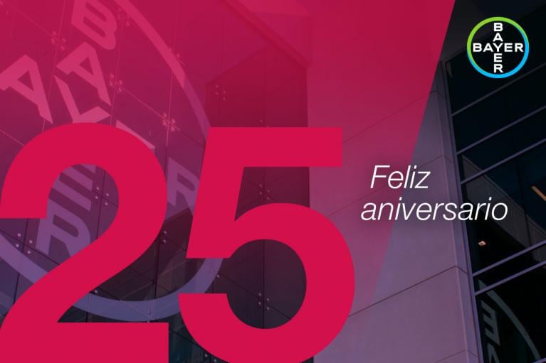 Large red "25" with "Feliz aniversario" text overlay on a building background. Bayer logo at top right corner.