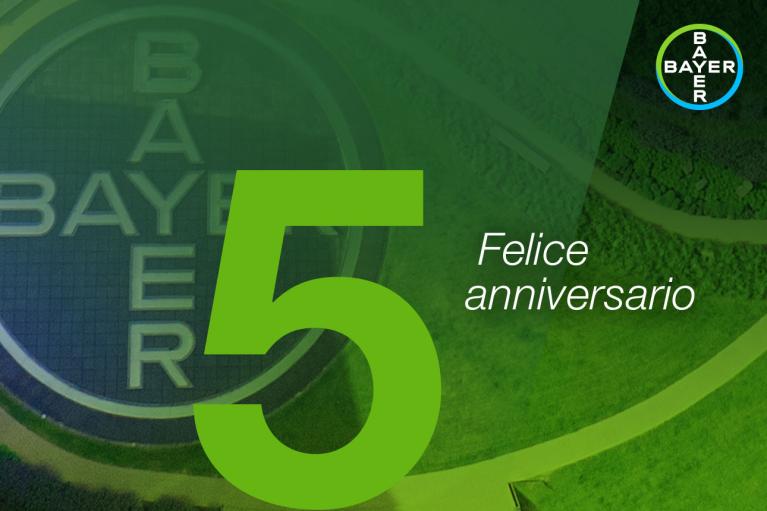 Green background with the number 5 and the text "Felice anniversario" next to a circular Bayer logo.