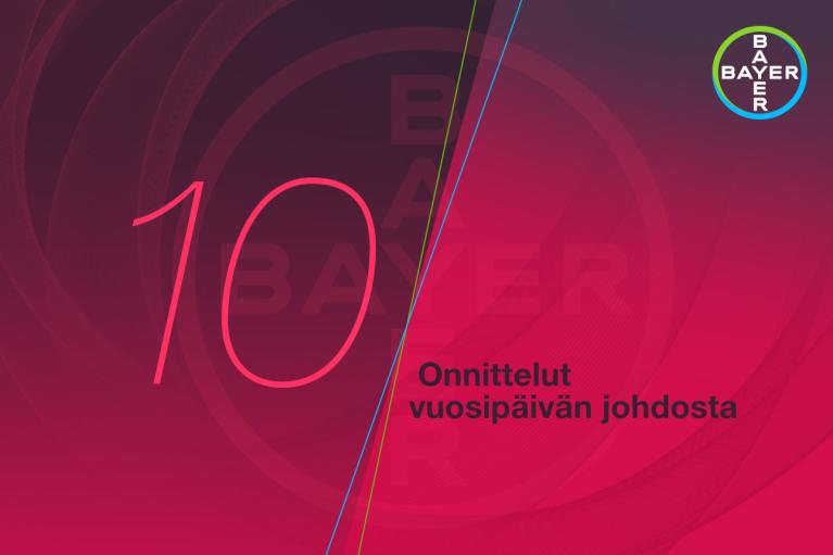 Red and pink background with the number 10 and Bayer logo in circular design. Finnish text reads "Onnittelut vuosipäivän johdosta," meaning "Congratulations on the anniversary.