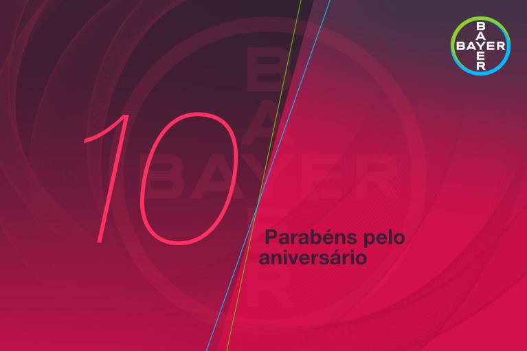 A red and purple graphic with the Bayer logo and the text "10 Parabéns pelo aniversário.