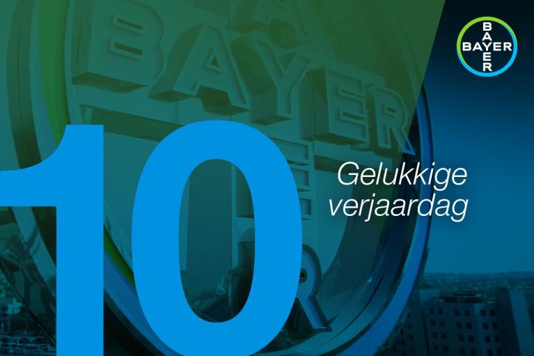 Blue number 10 and "Gelukkige verjaardag" text over a Bayer logo on a green and blue background.