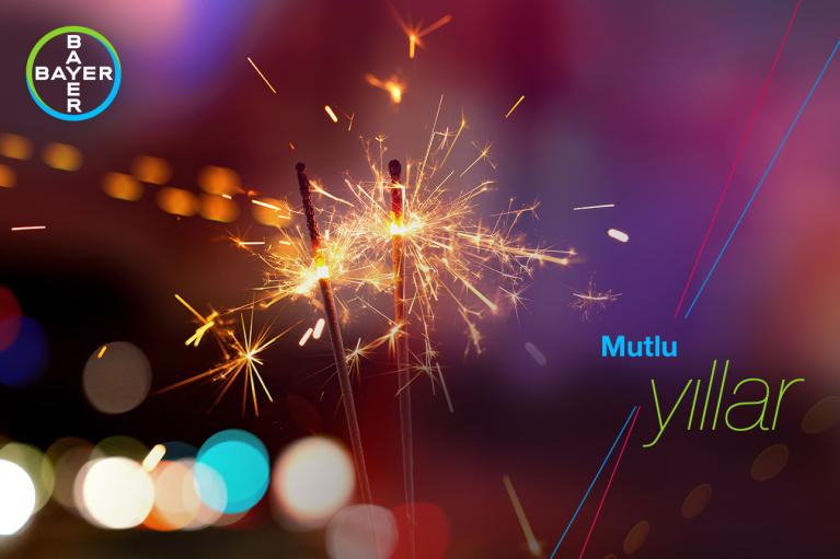 Three sparklers lit against a colorful bokeh background, with the Bayer logo and the text "Mutlu yıllar.