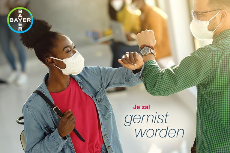 Two people wearing masks greet with elbow bumps. The text says "Je zal gemist worden" and there's a Bayer logo in the top left corner.