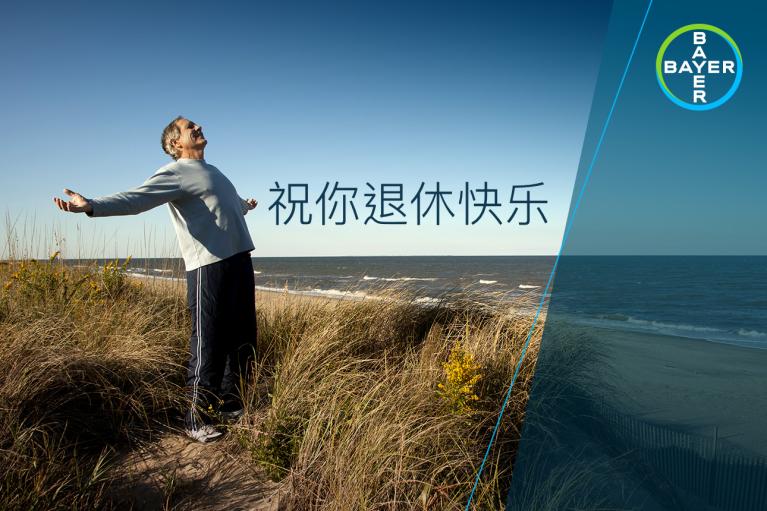 Person standing on grassy sand dune by the sea, arms outstretched. Chinese text and Bayer logo overlay.