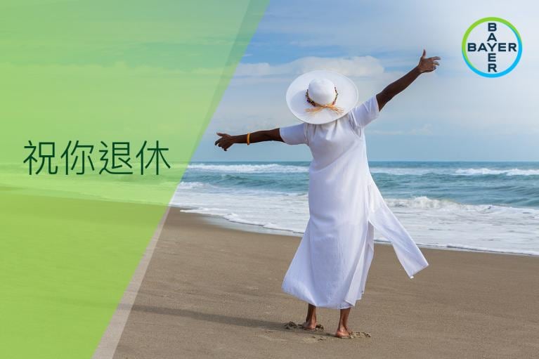 Person in white dress and hat standing on a beach with arms outstretched; ocean waves in background. Chinese text and Bayer logo on left.