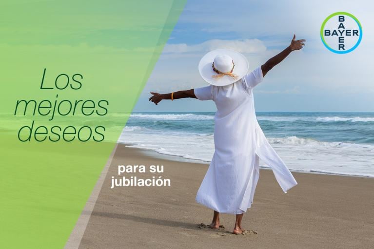 Person in white dress and hat joyfully stretches arms on a beach. Text in Spanish wishes a happy retirement.