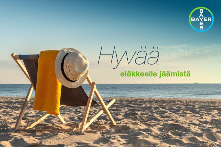 A beach chair with a yellow towel and a straw hat sits on a sandy beach. There's a Bayer logo in the top right corner and Finnish text that reads "Hyvää eläkkeelle jäämistä.