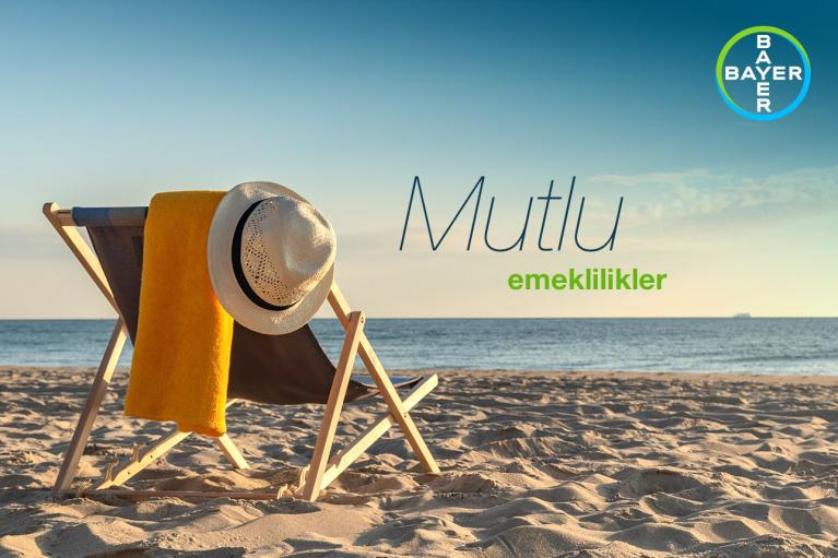 A beach chair with a sun hat and yellow towel is set on a sandy beach with a calm sea in the background. The Bayer logo is in the upper right corner. Text reads "Mutlu emeklilikler.