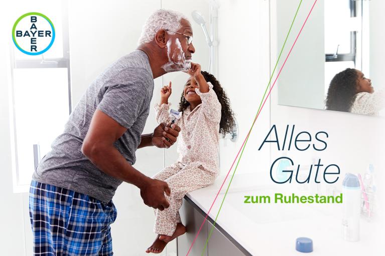 An older man and a child are smiling while he shaves in the bathroom. Text reads "Alles Gute zum Ruhestand," with a Bayer logo in the top left corner.