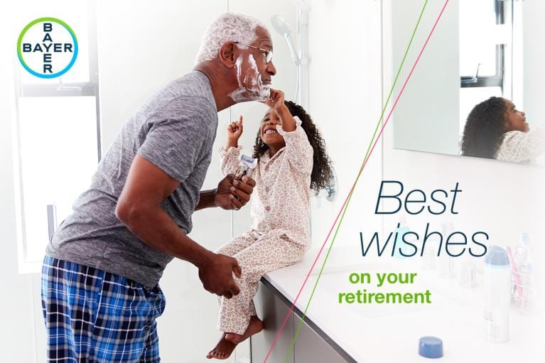 Older man shaving while a young girl touches his face. Text reads, "Best wishes on your retirement." Bayer logo in the top left corner.